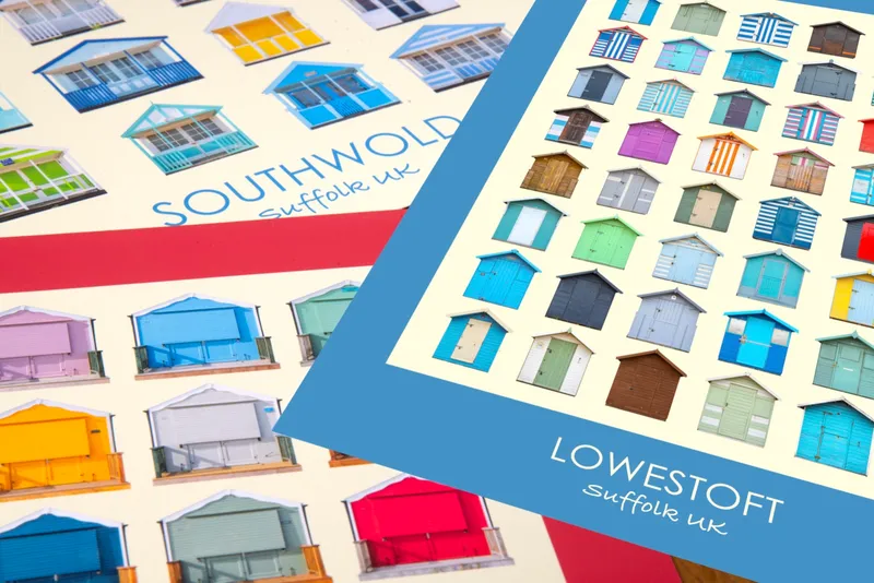 Two prints overlapping on a table: Southwold with a spade red border beneath, Lowestoft with a True Blue border on top