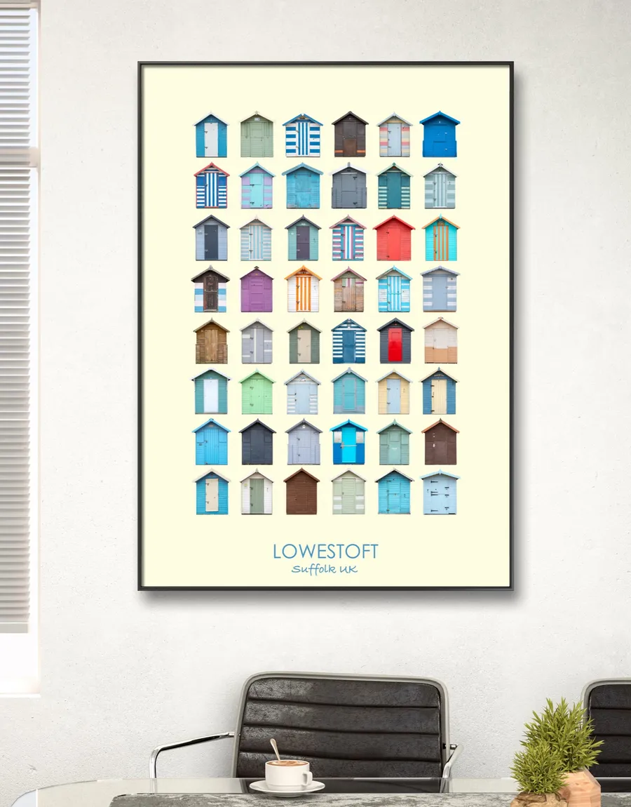 The Lowestoft print in a slim black frame on a pale wall above a desk with a coffee cup and a small plant