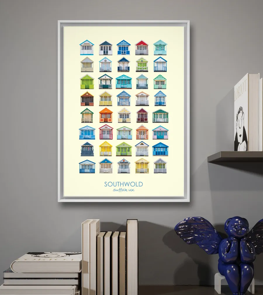 The Southwold print in a white frame on a grey wall, next to a shelf of books and a blue ceramic figure
